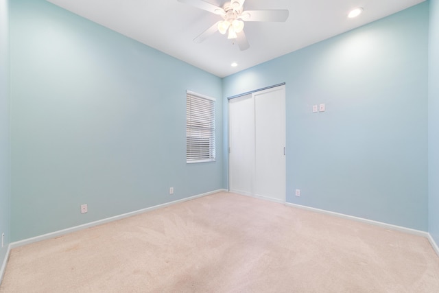 unfurnished room featuring light colored carpet and ceiling fan