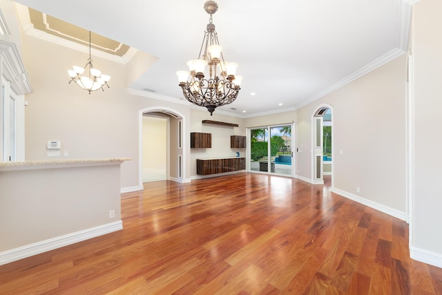 unfurnished living room with hardwood / wood-style floors, a notable chandelier, and ornamental molding