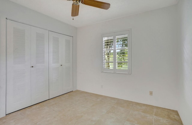 unfurnished bedroom featuring ceiling fan and a closet