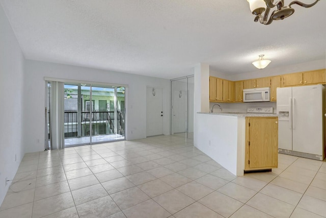 kitchen with light brown cabinets, white appliances, light tile patterned floors, a textured ceiling, and a chandelier