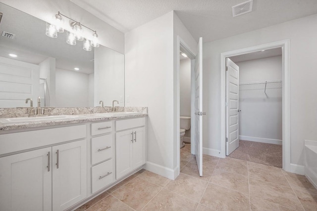 bathroom with vanity, tile patterned floors, a textured ceiling, and toilet