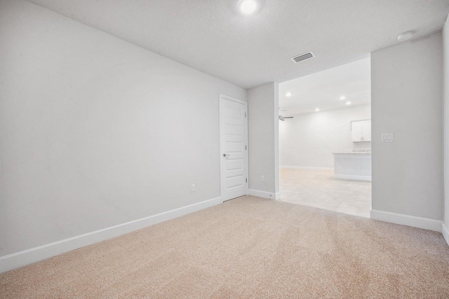 carpeted empty room with a textured ceiling