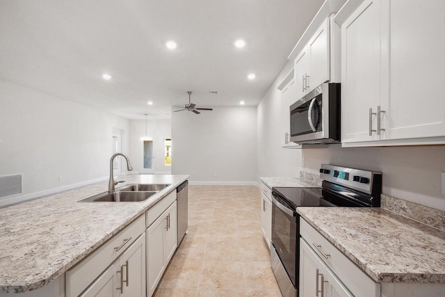 kitchen featuring white cabinets, sink, an island with sink, and appliances with stainless steel finishes