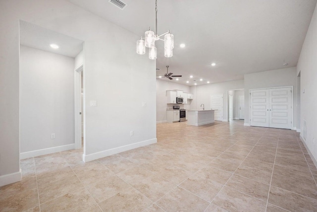 unfurnished living room featuring sink, light tile patterned flooring, and ceiling fan with notable chandelier