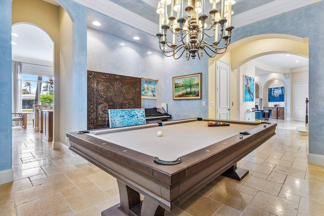 rec room with a towering ceiling, an inviting chandelier, ornamental molding, and pool table