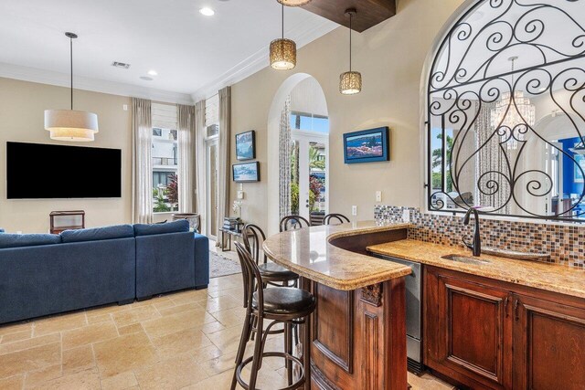 791 NE Marine Dr, Boca Raton, FL 33431 - bar with a sink, crown molding, tasteful backsplash, stone tile flooring, and decorative light fixtures