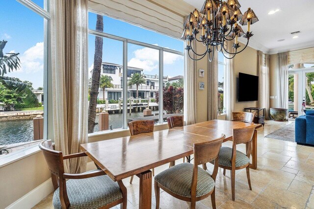 791 NE Marine Dr, Boca Raton, FL 33431 - dining area featuring a water view, stone tile floors, a chandelier, recessed lighting, and ornamental molding