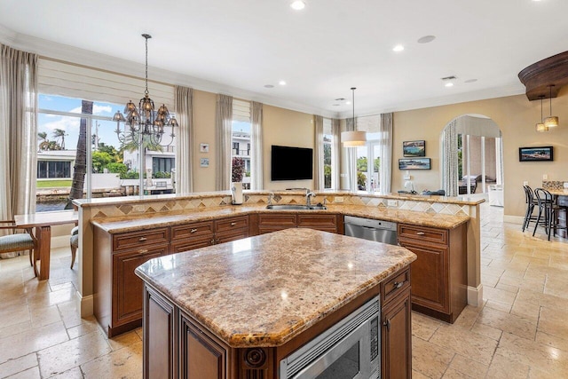 791 NE Marine Dr, Boca Raton, FL 33431 - kitchen featuring a spacious island, stone tile floors, appliances with stainless steel finishes, healthy amount of natural light, and recessed lighting