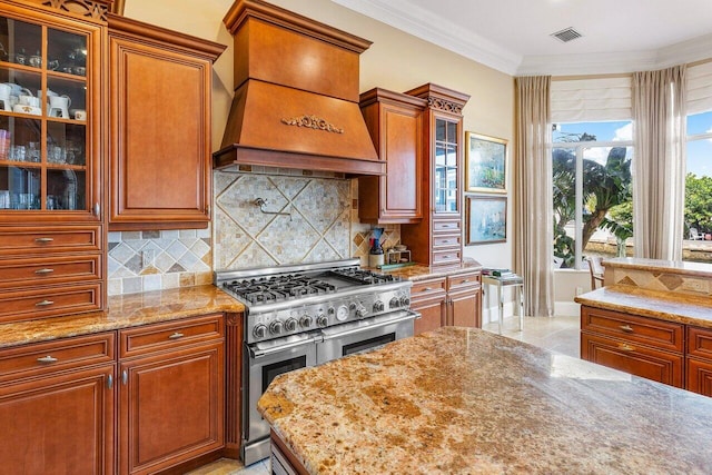 791 NE Marine Dr, Boca Raton, FL 33431 - kitchen featuring range with two ovens, premium range hood, light stone counters, decorative backsplash, and crown molding