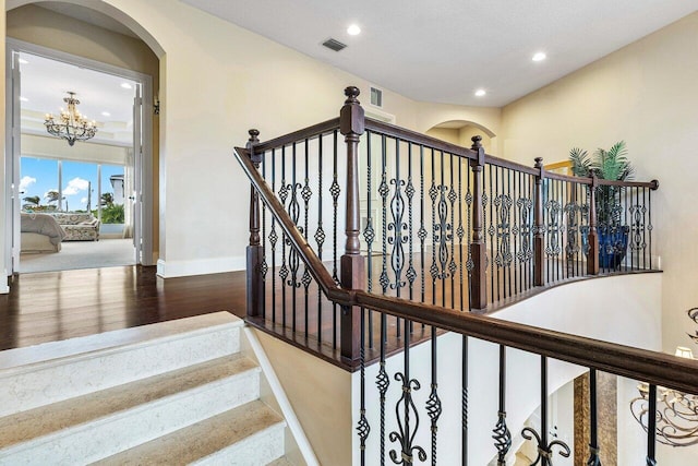 791 NE Marine Dr, Boca Raton, FL 33431 - staircase featuring baseboards, wood finished floors, recessed lighting, arched walkways, and a chandelier