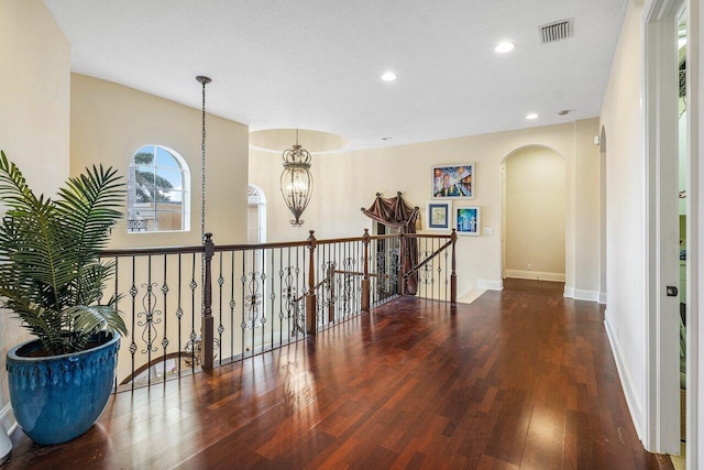 791 NE Marine Dr, Boca Raton, FL 33431 - hallway featuring arched walkways, wood finished floors, an upstairs landing, baseboards, and recessed lighting