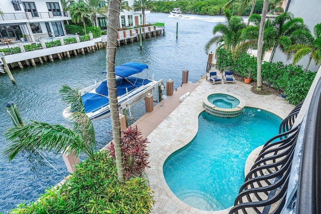 791 NE Marine Dr, Boca Raton, FL 33431 - view of pool featuring a water view, a pool with connected hot tub, a dock, and boat lift