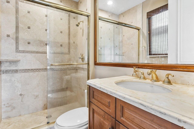 bathroom with vanity, an enclosed shower, and toilet