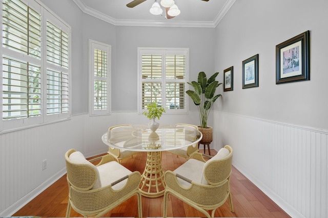 dining area with ceiling fan, crown molding, wood-type flooring, and a healthy amount of sunlight