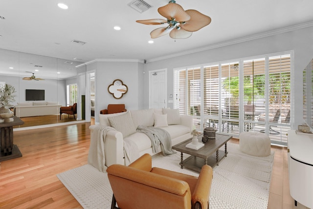 living room featuring crown molding, ceiling fan, and light hardwood / wood-style flooring