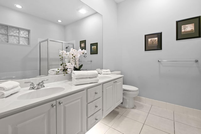 bathroom with a shower with door, vanity, tile patterned floors, and toilet