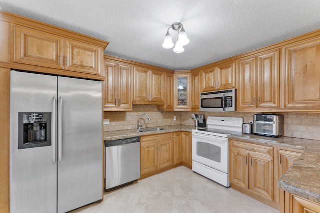 kitchen with tasteful backsplash, a textured ceiling, stainless steel appliances, sink, and light tile patterned floors