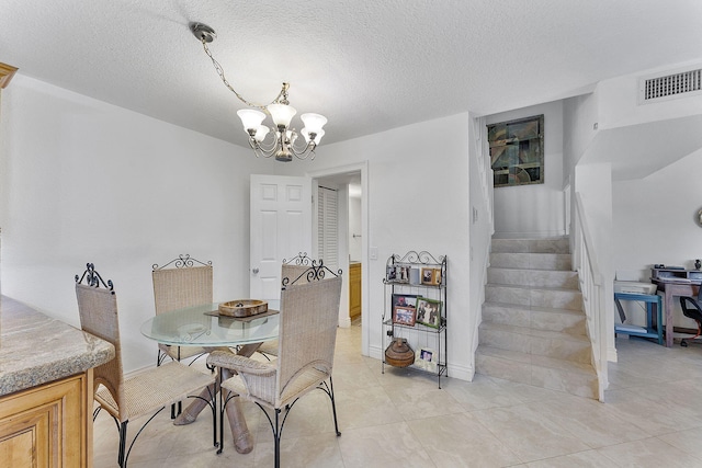 dining space featuring light tile patterned floors, a chandelier, and a textured ceiling