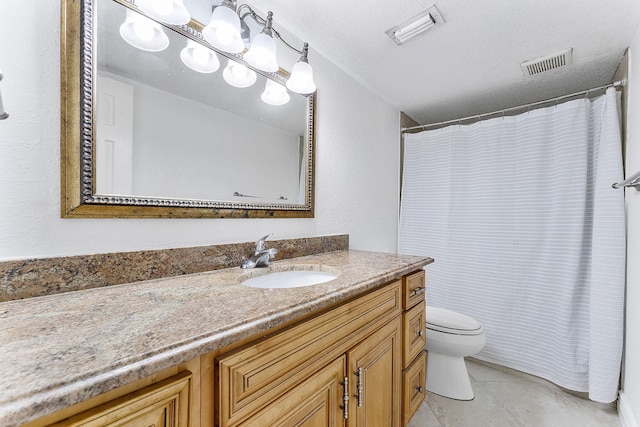 bathroom with tile patterned floors, vanity, toilet, and a textured ceiling