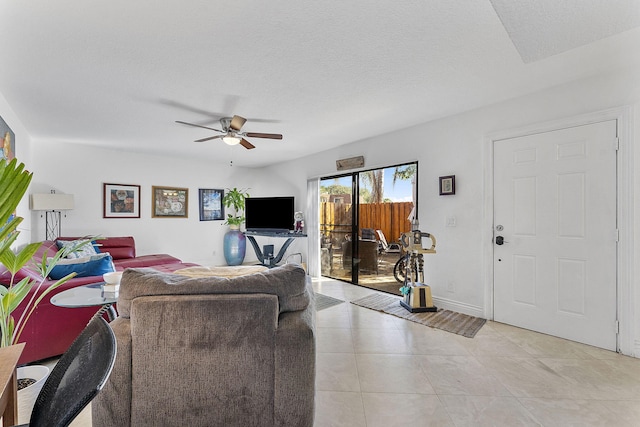 living room with ceiling fan and a textured ceiling