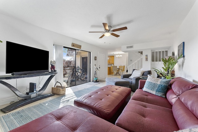 living room with a textured ceiling and ceiling fan with notable chandelier