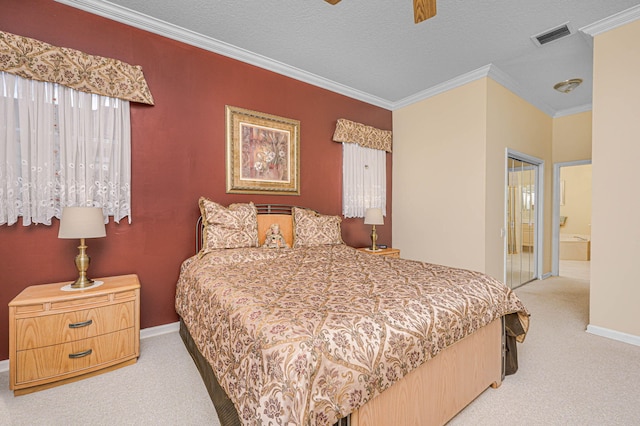 carpeted bedroom with ensuite bath, ceiling fan, a textured ceiling, and ornamental molding