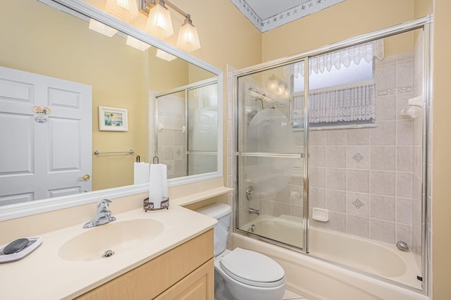 full bathroom featuring vanity, toilet, and bath / shower combo with glass door