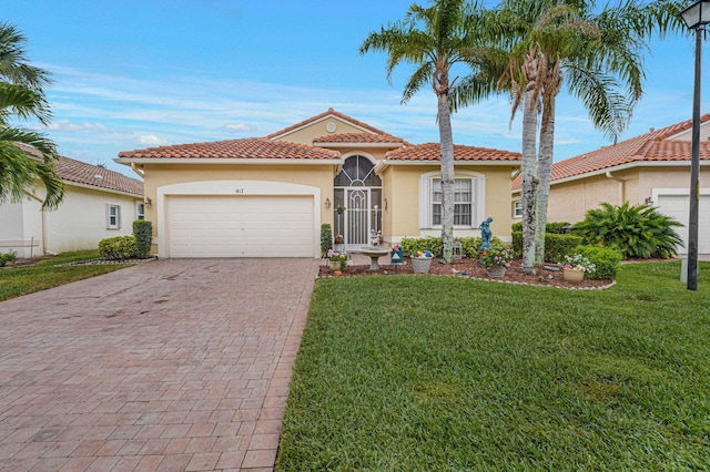 mediterranean / spanish-style house with a garage and a front lawn