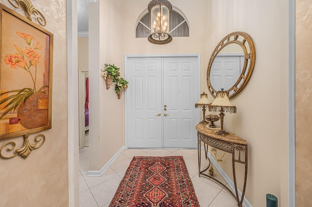 entryway featuring light tile patterned floors, ornamental molding, and a notable chandelier