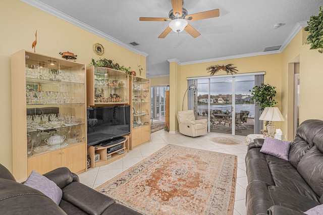 tiled living room with ceiling fan and crown molding