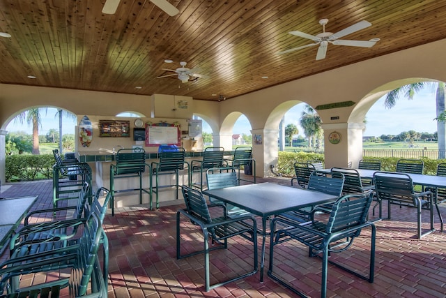 view of patio with ceiling fan, a rural view, and exterior bar