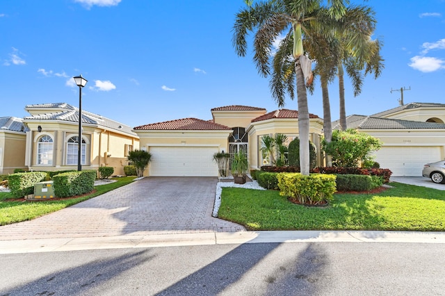 mediterranean / spanish-style home featuring a front lawn and a garage