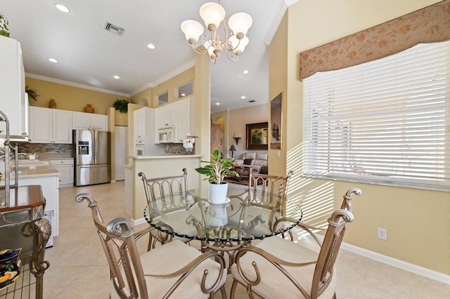 dining area with a notable chandelier, ornamental molding, and light tile patterned floors