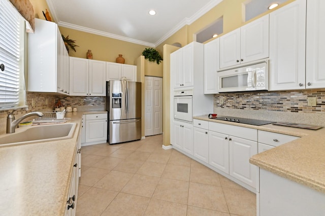 kitchen with white appliances, light tile patterned floors, sink, white cabinetry, and ornamental molding