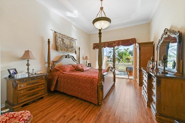 bedroom featuring a tray ceiling, crown molding, access to outside, and dark hardwood / wood-style floors