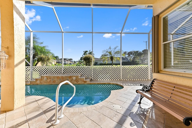 view of pool featuring glass enclosure and a patio