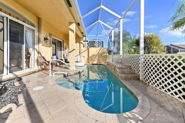 view of swimming pool with a patio and glass enclosure