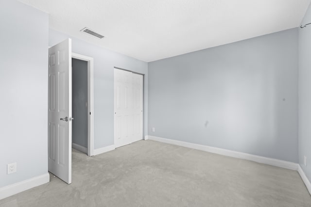 unfurnished bedroom featuring light carpet