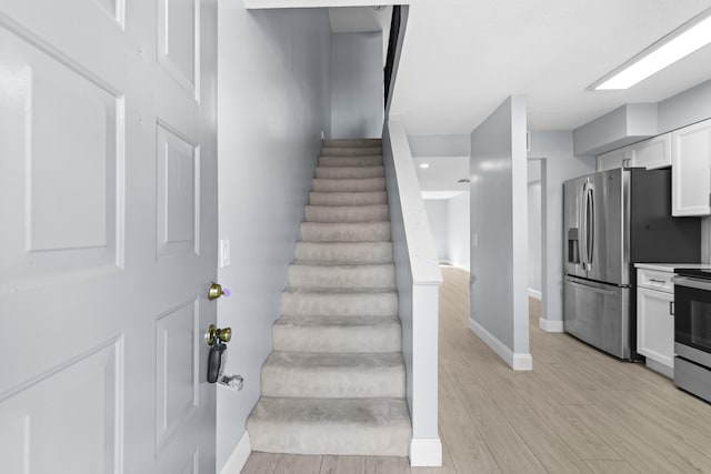 staircase with hardwood / wood-style flooring