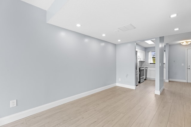 interior space featuring stainless steel fridge and light hardwood / wood-style floors