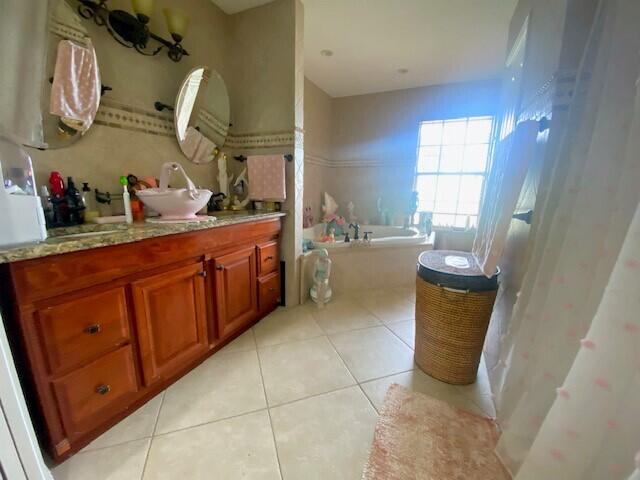 bathroom with tile patterned flooring, vanity, and a bathtub