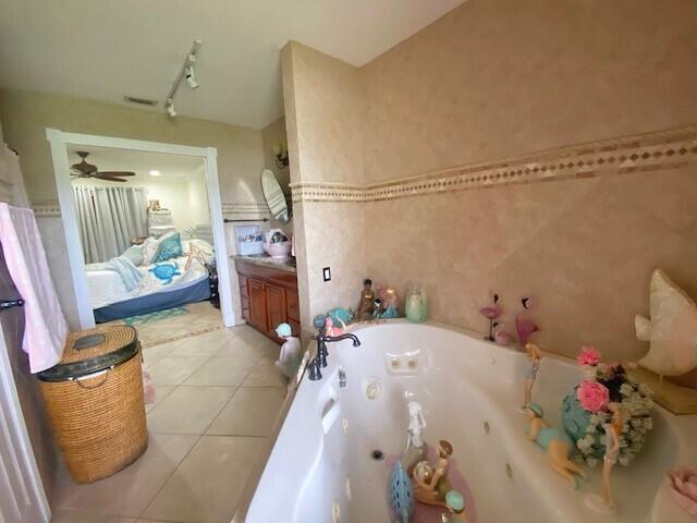 bathroom with vanity, track lighting, tile patterned floors, and a bathing tub