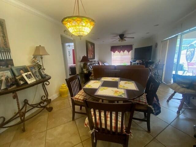 dining area with tile patterned floors, ceiling fan, and ornamental molding