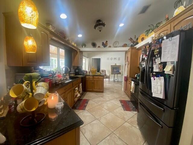 kitchen featuring kitchen peninsula, sink, black appliances, light tile patterned floors, and decorative light fixtures