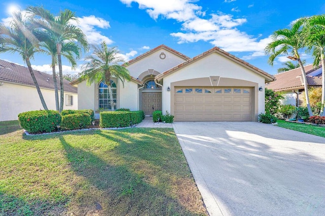 mediterranean / spanish-style house featuring a garage and a front lawn