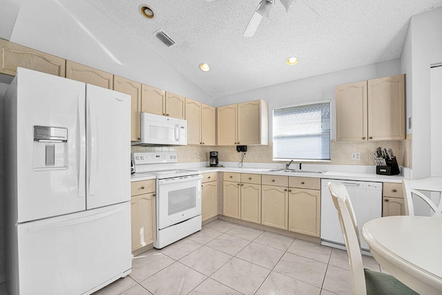 kitchen featuring white appliances, sink, light brown cabinetry, and vaulted ceiling