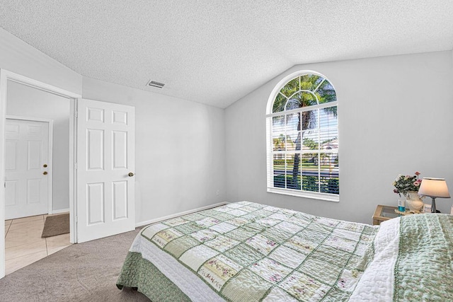 carpeted bedroom featuring a textured ceiling and vaulted ceiling