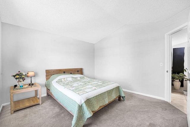 carpeted bedroom with a textured ceiling and vaulted ceiling