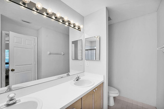 bathroom with tile patterned flooring, vanity, and toilet