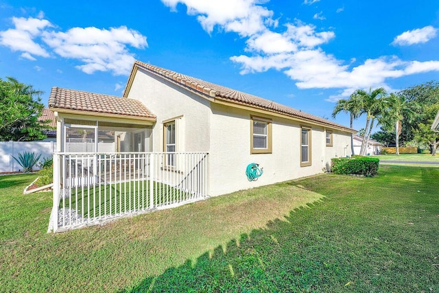 view of side of home featuring a yard and a sunroom